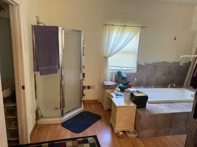 bathroom with hardwood / wood-style flooring and independent shower and bath