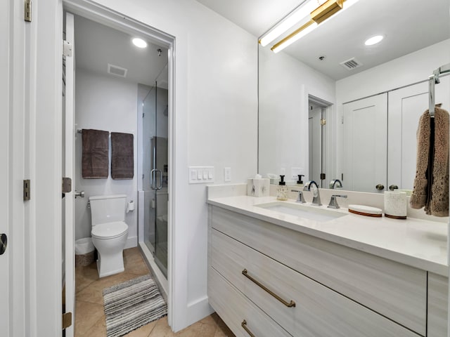 bathroom with vanity, tile patterned floors, toilet, and walk in shower