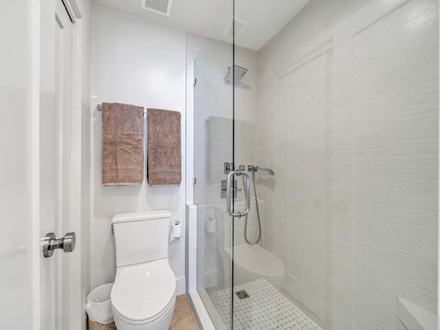 bathroom featuring tile patterned floors, a shower with door, and toilet