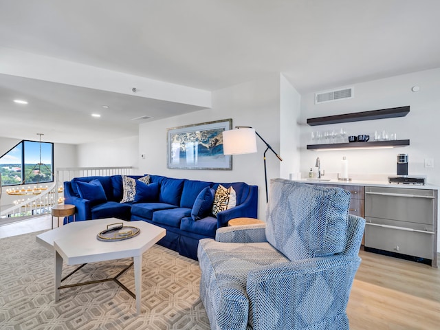 living room featuring wet bar and light wood-type flooring