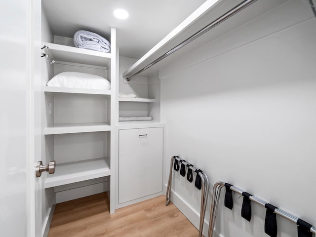 walk in closet with light hardwood / wood-style floors