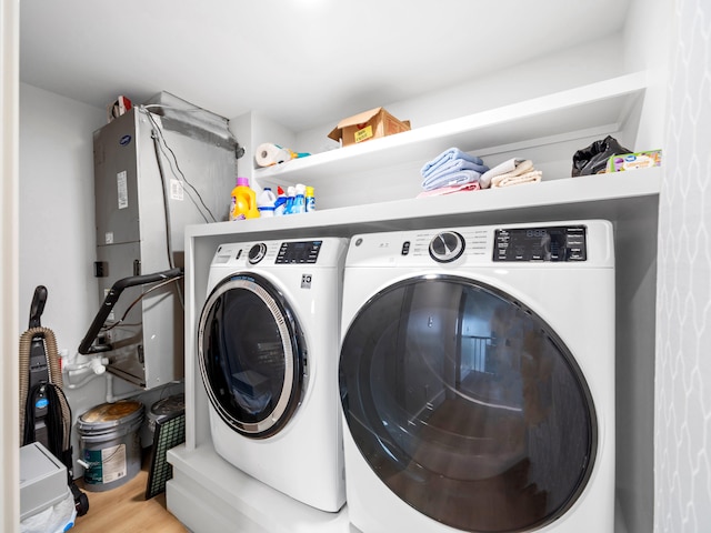 clothes washing area with independent washer and dryer and light hardwood / wood-style floors