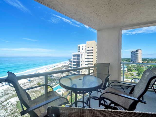 balcony with a water view and a beach view