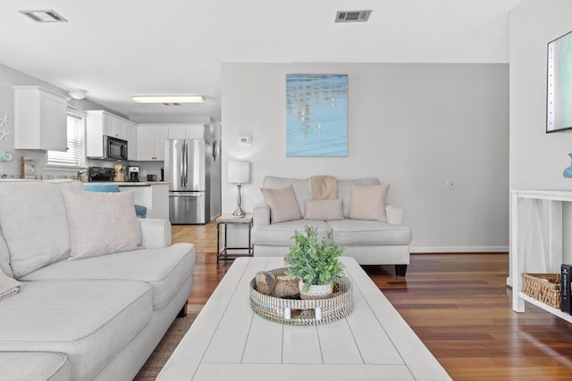 living room with wood-type flooring and a textured ceiling