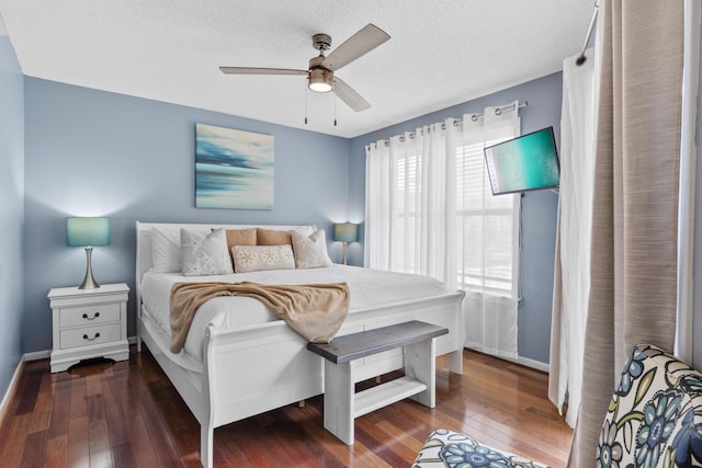 bedroom with a textured ceiling, ceiling fan, and dark hardwood / wood-style floors