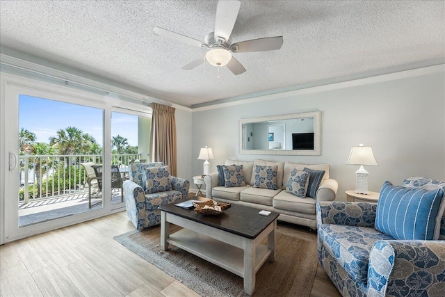 living room with ceiling fan, crown molding, wood-type flooring, and a textured ceiling