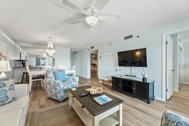 living room featuring hardwood / wood-style flooring, ceiling fan, and a textured ceiling