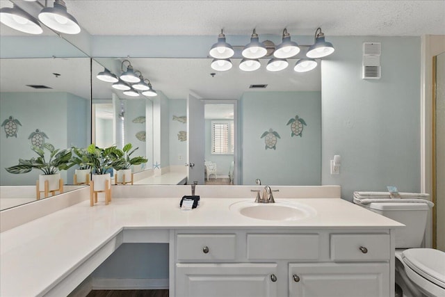 bathroom with vanity, a textured ceiling, and toilet