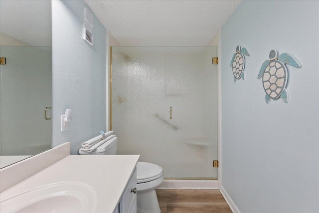 bathroom with toilet, a shower with shower door, a textured ceiling, vanity, and hardwood / wood-style flooring