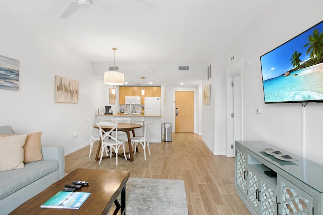 living room featuring ceiling fan and light hardwood / wood-style floors