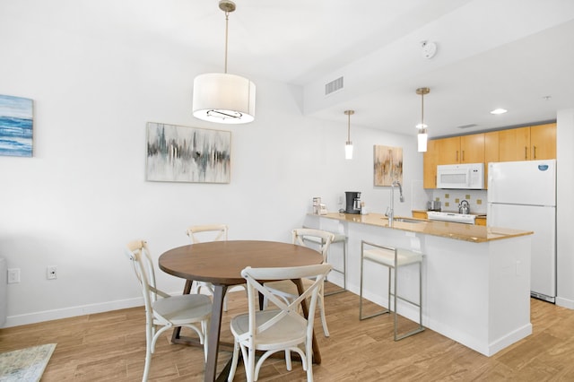 dining room featuring light hardwood / wood-style floors and sink