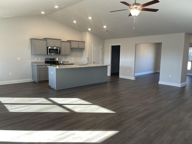 kitchen featuring gray cabinetry, a kitchen island with sink, dark hardwood / wood-style floors, ceiling fan, and appliances with stainless steel finishes