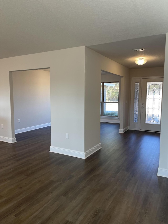 entryway with a textured ceiling and dark wood-type flooring