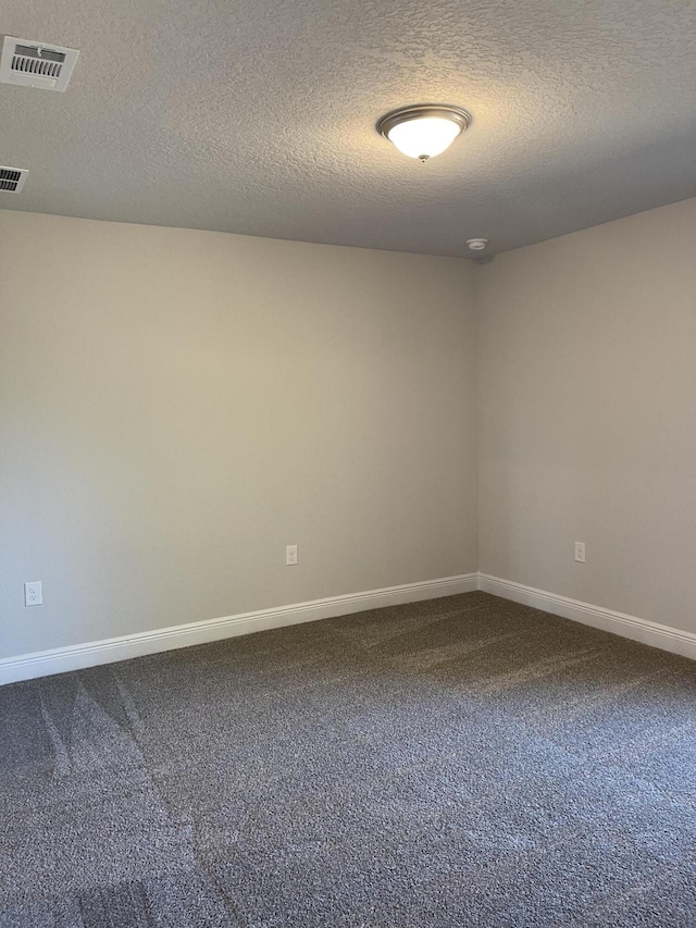 unfurnished room featuring carpet floors and a textured ceiling