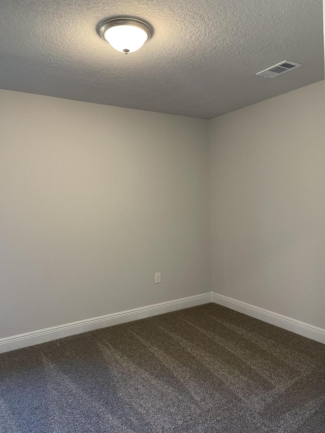 carpeted empty room with a textured ceiling