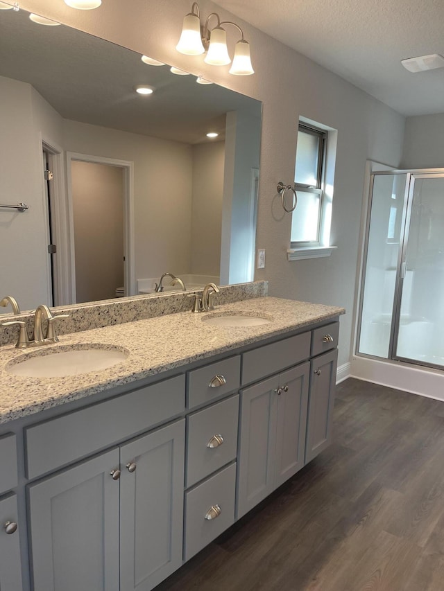 bathroom featuring wood-type flooring, vanity, toilet, and walk in shower