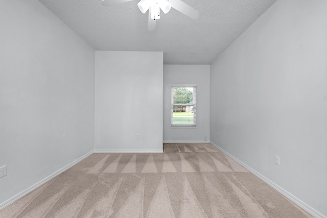 carpeted spare room with ceiling fan and a textured ceiling