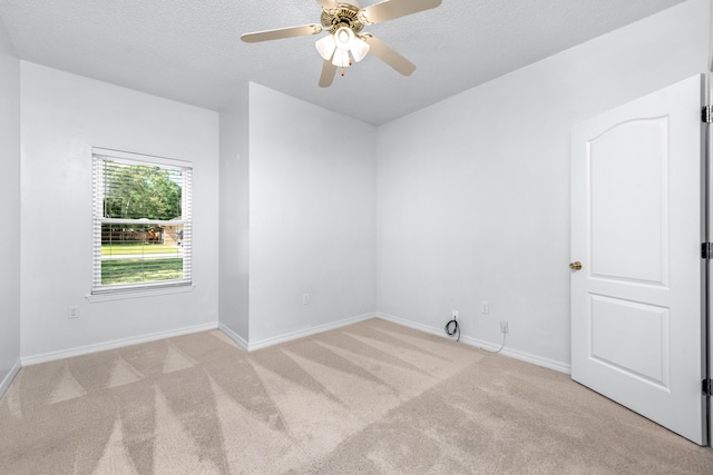 carpeted empty room featuring ceiling fan and a textured ceiling