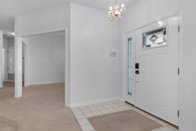 foyer entrance featuring light carpet, baseboards, a chandelier, and light tile patterned flooring