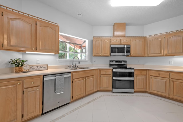 kitchen featuring light brown cabinetry, a textured ceiling, stainless steel appliances, and sink