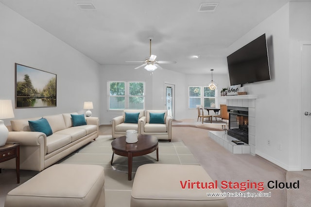 carpeted living room featuring a tiled fireplace, ceiling fan, and a healthy amount of sunlight