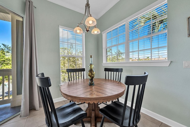 dining space with crown molding, light tile patterned floors, and an inviting chandelier