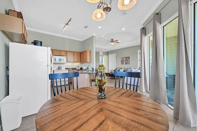 tiled dining space with track lighting, ceiling fan, ornamental molding, and sink