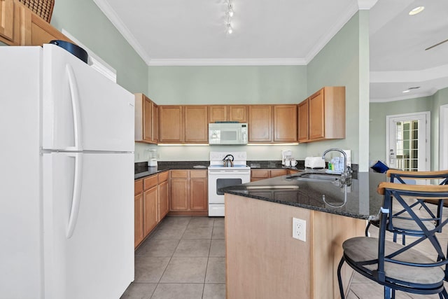 kitchen with sink, white appliances, a kitchen bar, light tile patterned floors, and ornamental molding