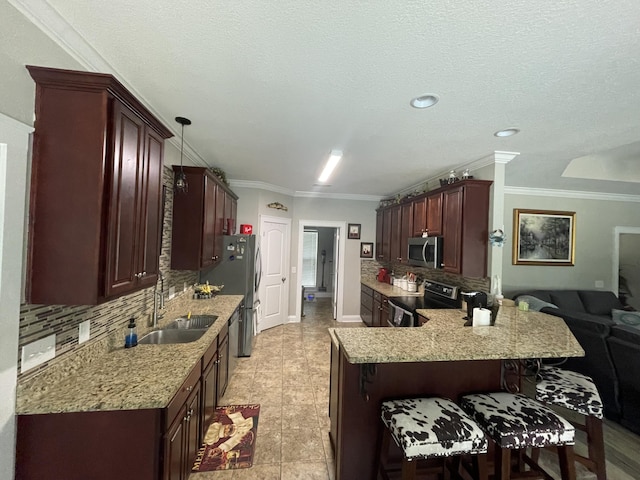 kitchen with a breakfast bar, sink, hanging light fixtures, kitchen peninsula, and stainless steel appliances