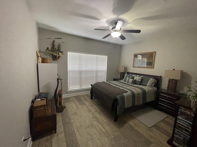 bedroom with ceiling fan and wood-type flooring