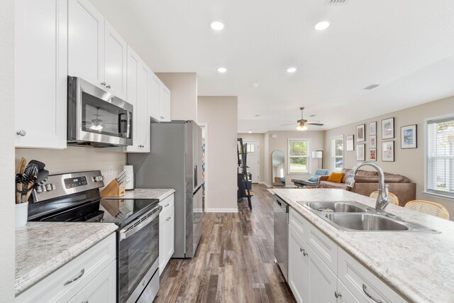 kitchen featuring white cabinetry, wood-type flooring, ceiling fan, stainless steel appliances, and sink