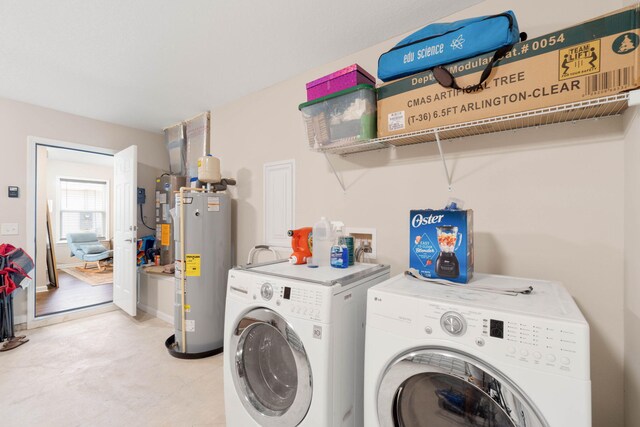 laundry area featuring electric water heater and separate washer and dryer