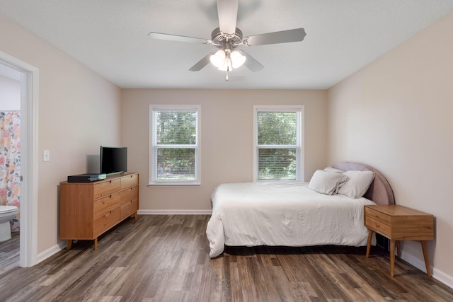 bedroom with dark wood-type flooring, connected bathroom, and ceiling fan