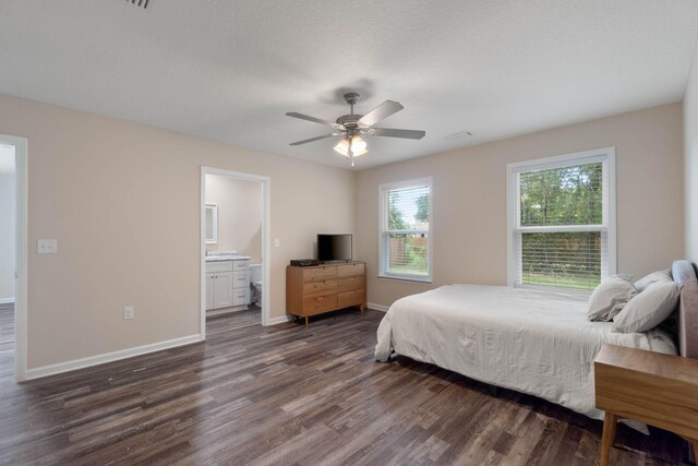 bedroom with ensuite bath, ceiling fan, and dark wood-type flooring