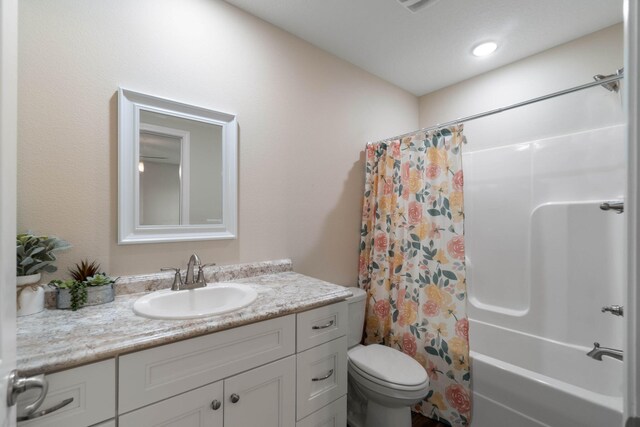 full bathroom featuring shower / bath combination with curtain, toilet, and vanity