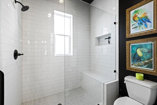 bathroom featuring a tile shower and toilet