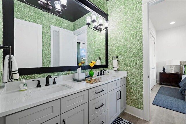 bathroom featuring hardwood / wood-style floors, vanity, and a chandelier