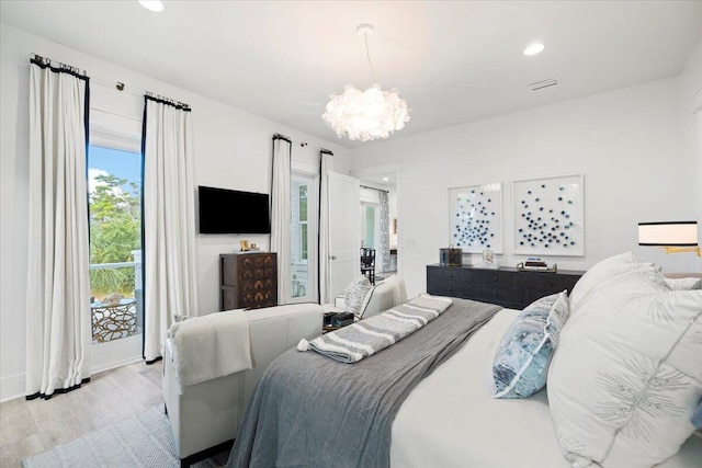 bedroom with light wood-type flooring and an inviting chandelier