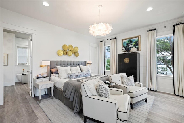 bedroom featuring light hardwood / wood-style flooring and a chandelier