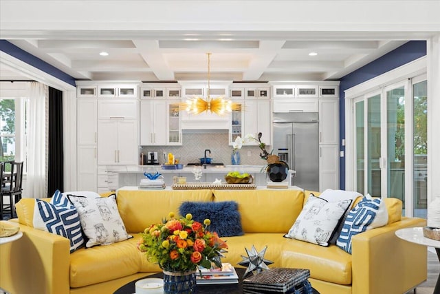 living room featuring beam ceiling, coffered ceiling, and sink