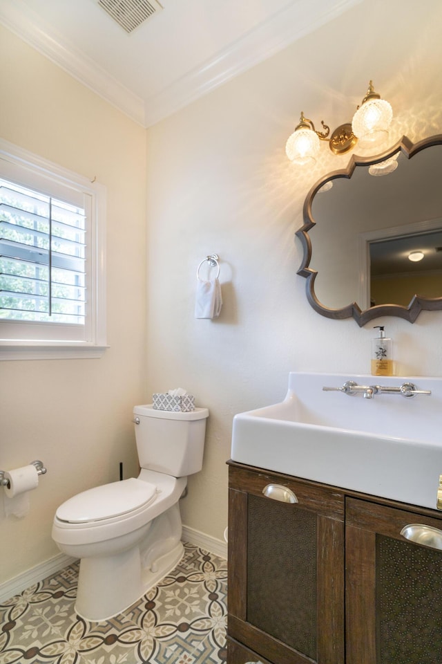 bathroom with tile patterned flooring, vanity, crown molding, and toilet