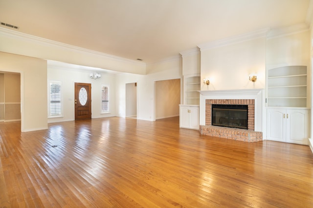 unfurnished living room featuring crown molding, light wood-type flooring, built in features, and a fireplace