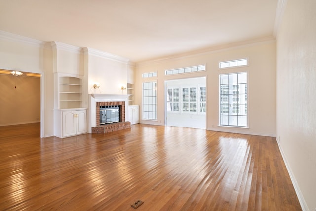 unfurnished living room featuring ornamental molding, wood-type flooring, and a fireplace