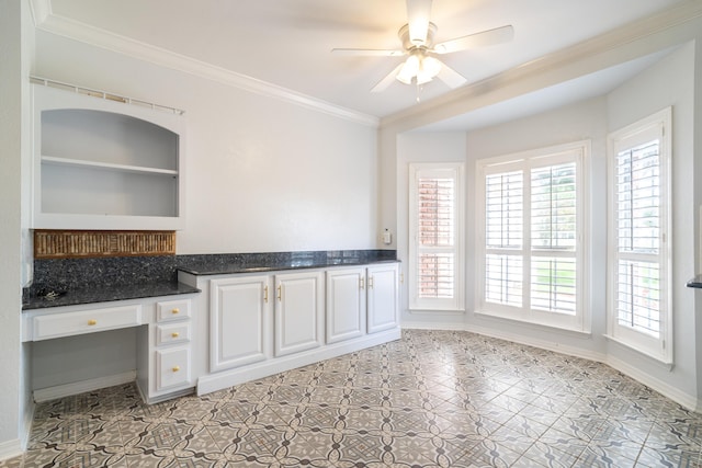 kitchen with built in desk, built in features, white cabinetry, ceiling fan, and crown molding