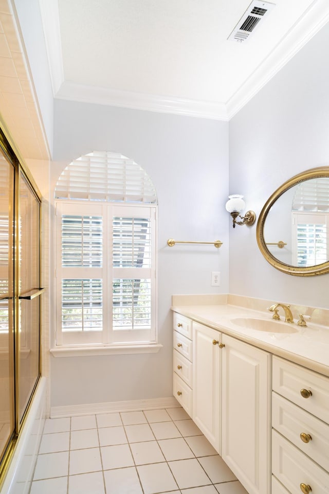 bathroom with tile patterned flooring, crown molding, vanity, and bath / shower combo with glass door