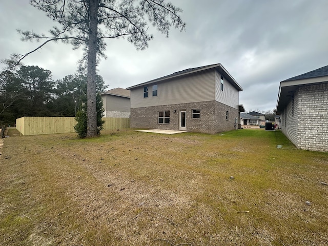 rear view of house featuring a lawn and a patio