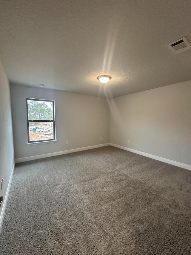 carpeted empty room with a textured ceiling