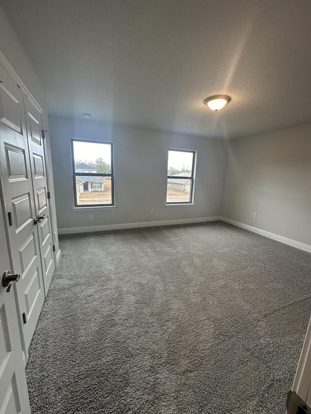 carpeted spare room featuring a textured ceiling