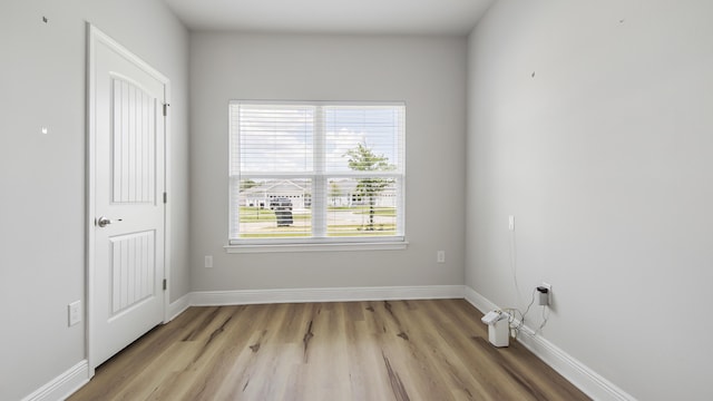 empty room featuring light wood finished floors and baseboards