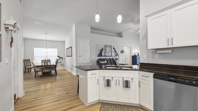 kitchen featuring a sink, a peninsula, white cabinets, and stainless steel dishwasher